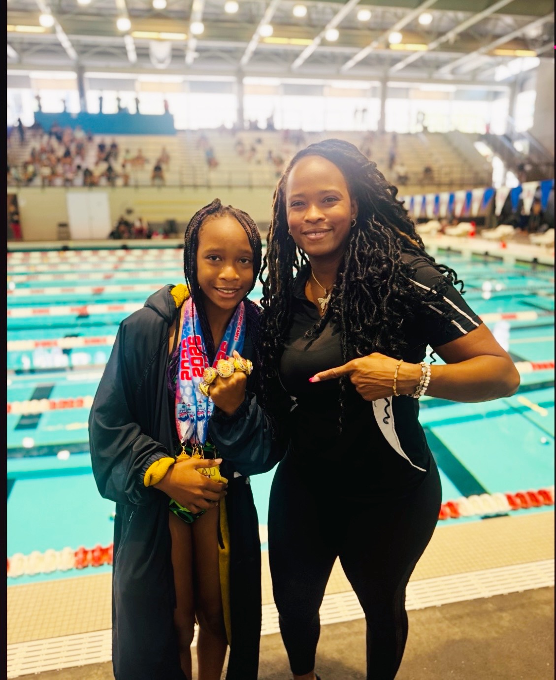 Coach Bobbi Perry celebrating Kaila Perry’s championship medals beside the pool