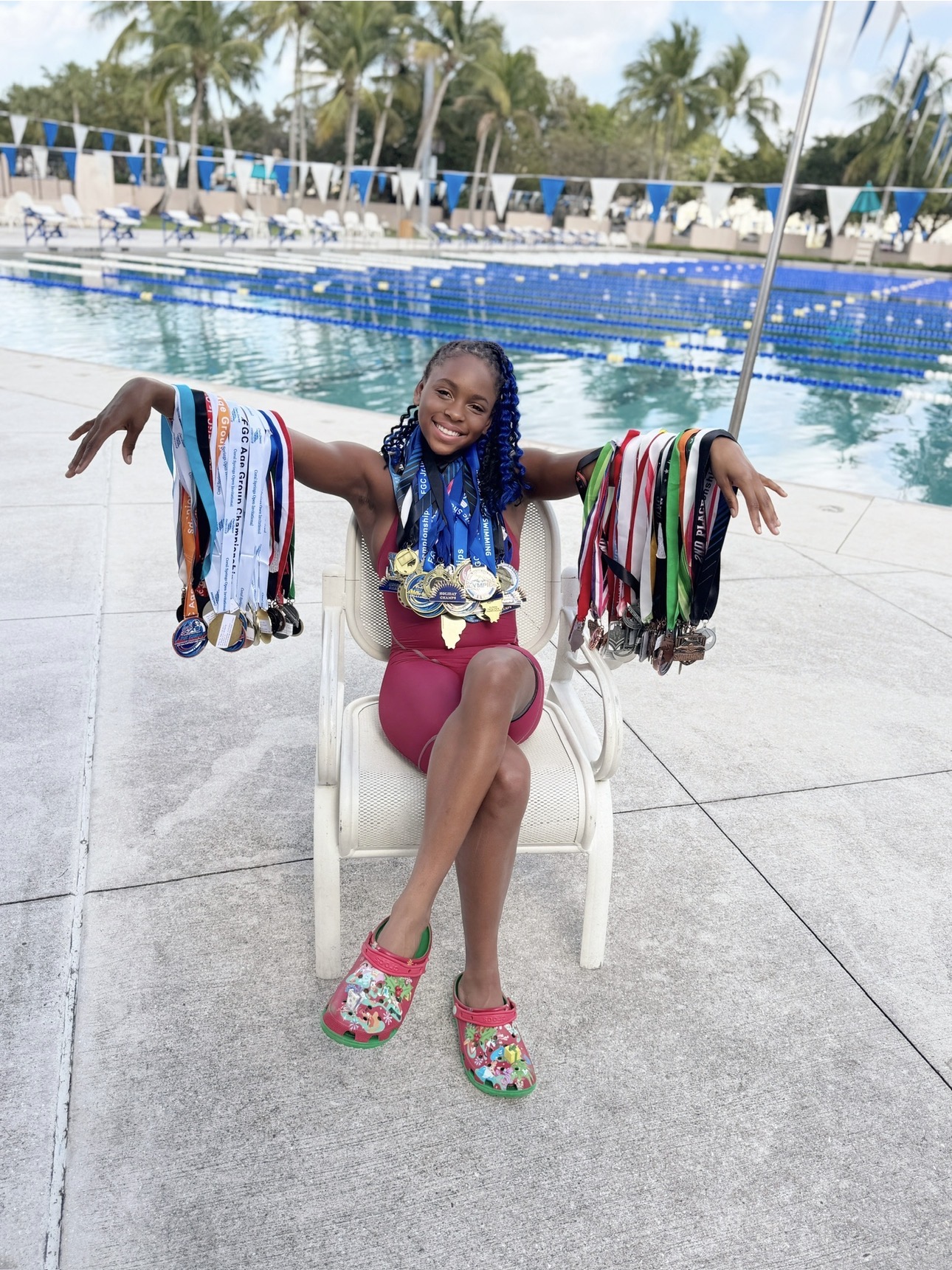 Kira Perry displaying her collection of swimming championship medals