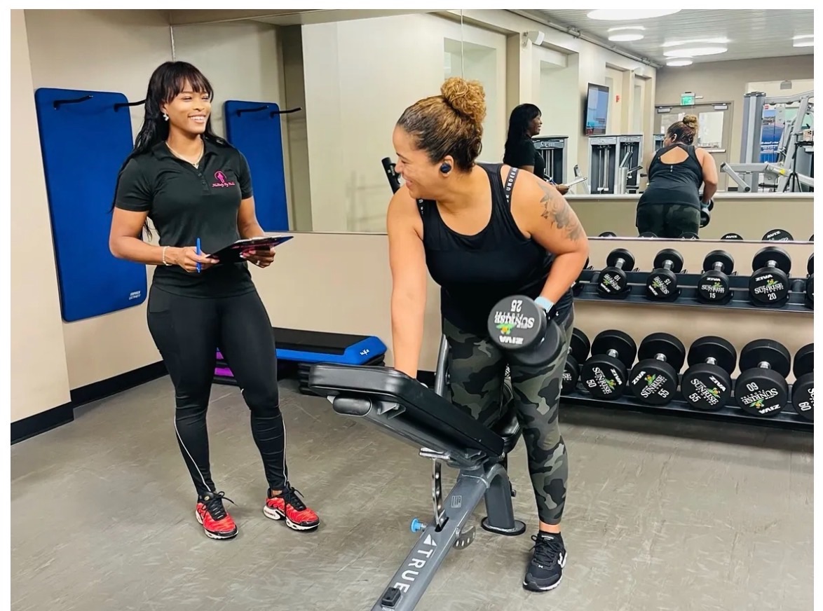 Bobbi coaching a personal-training client during a dumbbell workout