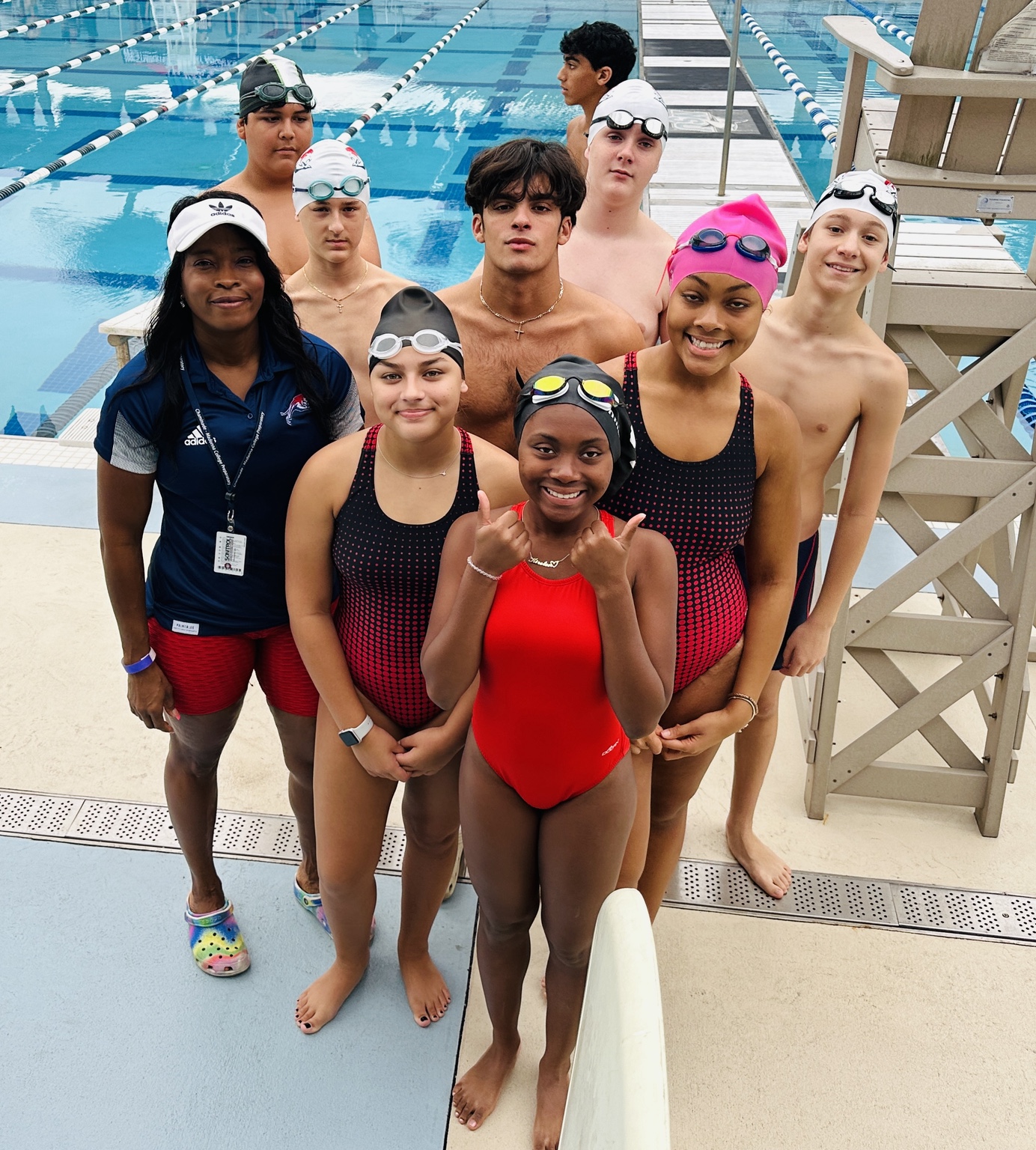 Bobbi with a group of competitive swimmers beside the pool